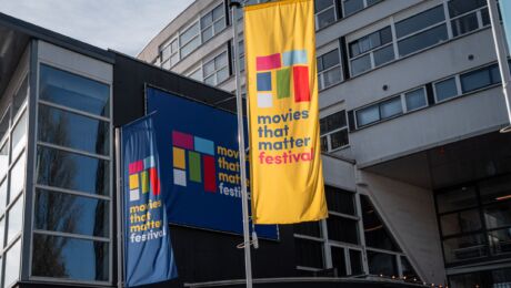 Wapperende banieren met Movies that Matter Logo in blauw en geel voor het Filmhuis Den Haag