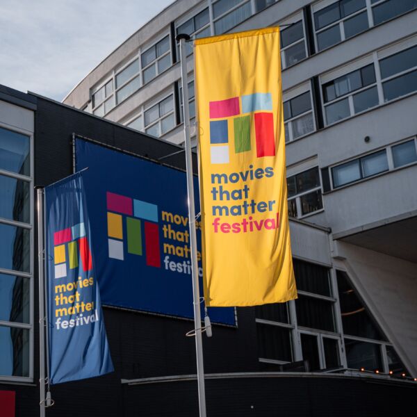 Wapperende banieren met Movies that Matter Logo in blauw en geel voor het Filmhuis Den Haag