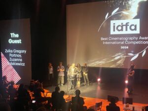 Speech op podium van IDFA Award for Best Cinematography - International Competition: The Guest, cinematographers Zvika Gregory Portnoy, Zuzanna Solakiewicz