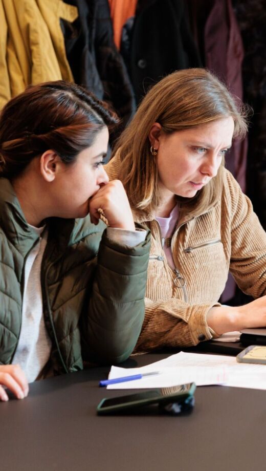 Twee vrouwen kijken naar het scherm van een laptop.