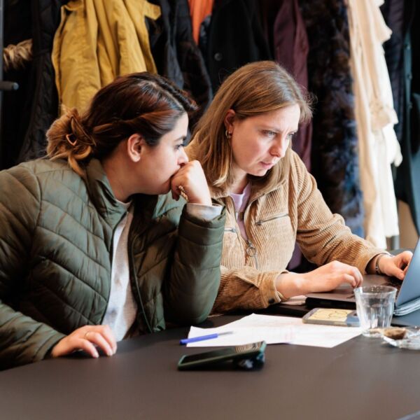 Twee vrouwen kijken naar het scherm van een laptop.