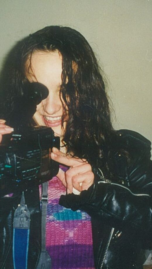 vrouwelijke regisseur kijkt door de lens van haar videocamera