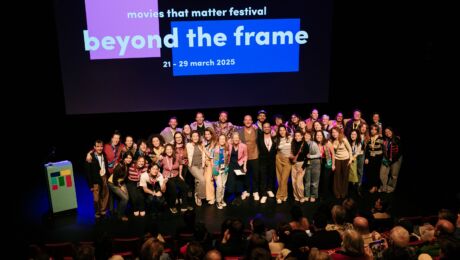 Groepsfoto van hele team van Movies that Matter op het podium van een theaterzaal
